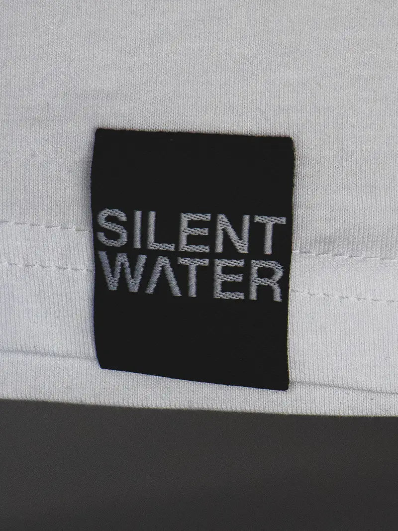 schwarzes Silent Water Badge auf weißem Shirt