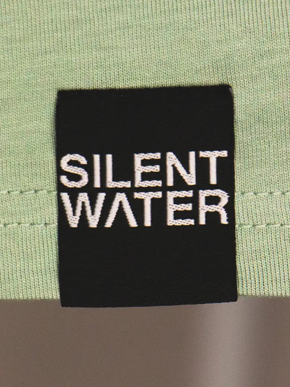 schwarzer Badge auf grünem T-Shirt
