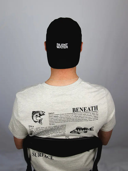 Mann sitzt auf Stuhl mit Cap und dem Rücken zur Kamera